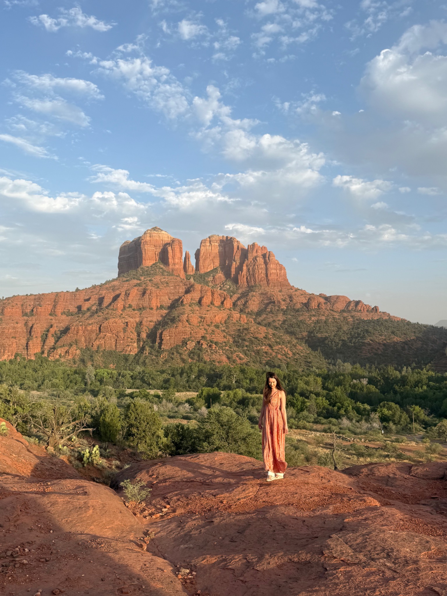 Jacquelyn standing in the Sedona red rocks with Cathedral Rock behind her