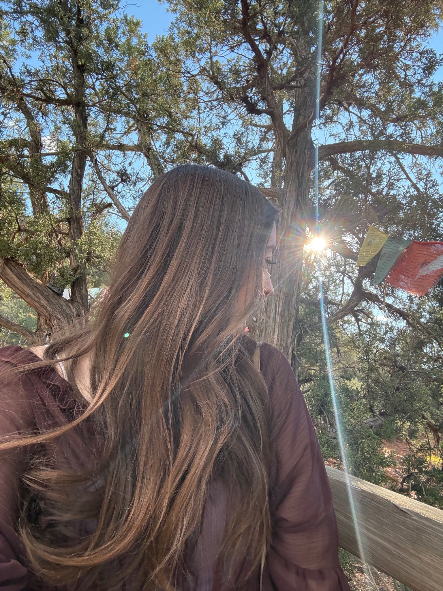 Jacquelyn in warm sunlight near prayer flags in Sedona